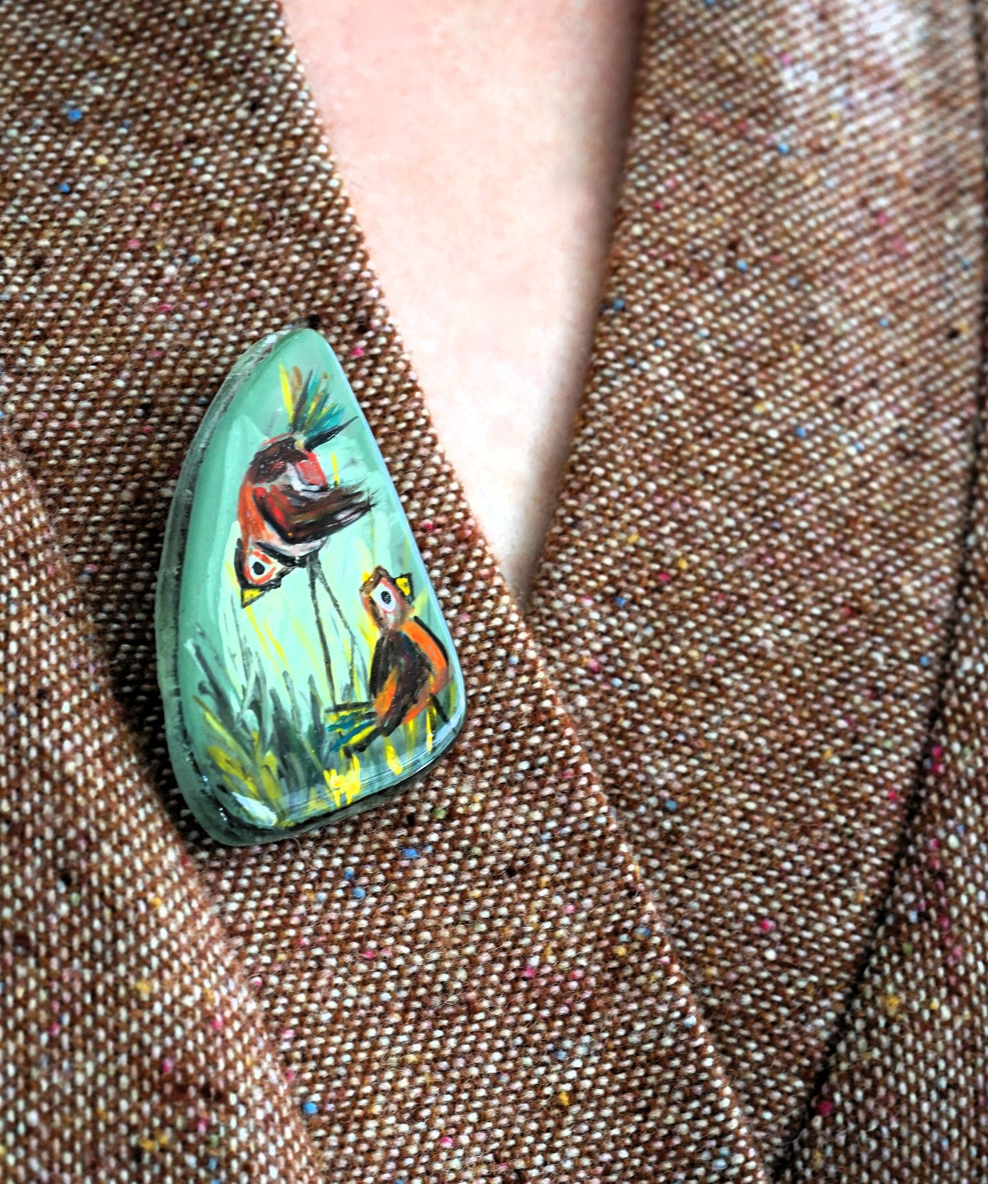 Hand-painted brooch with birds on a textured fabric background