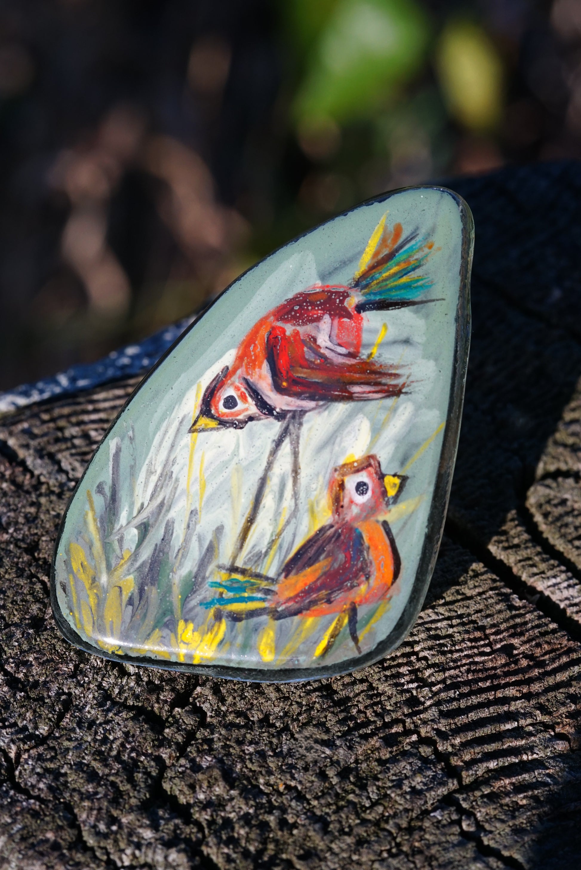 Colorful brooch with two birds on a natural background